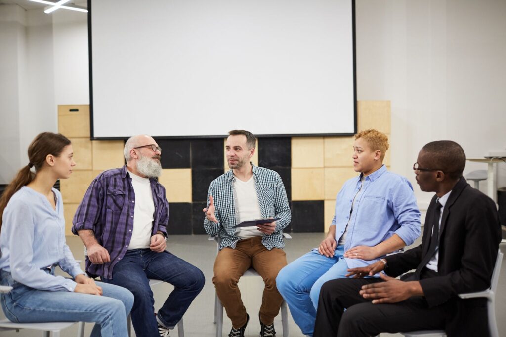 a group of people sitting in circle during addiction therapy